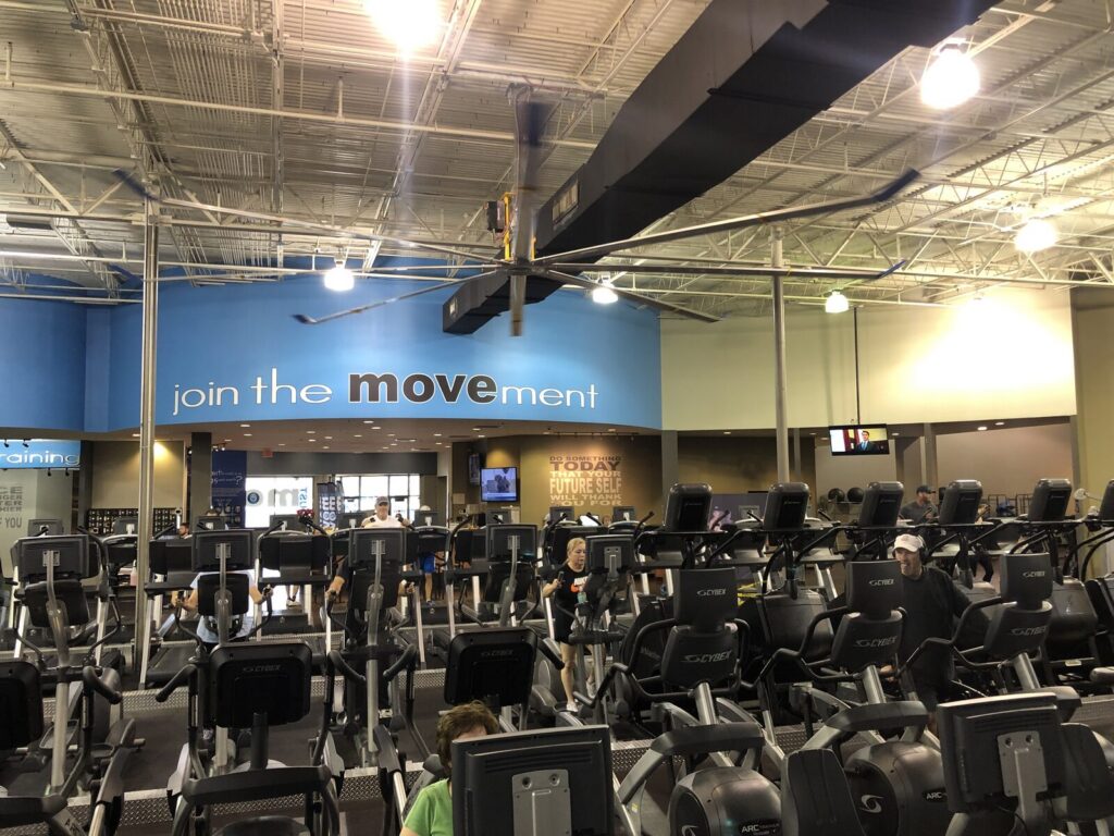 Interior of Just Move gym in Lakeland, Florida with strength equipment, turf track, and cycling studio
